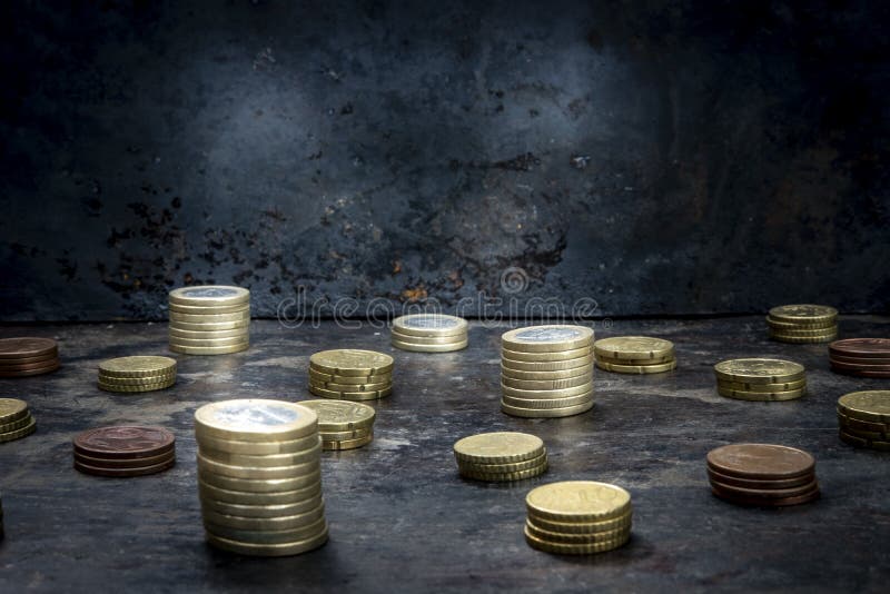 Mosaic with pattern made up of euro coins on a dark black background with ripped metal details