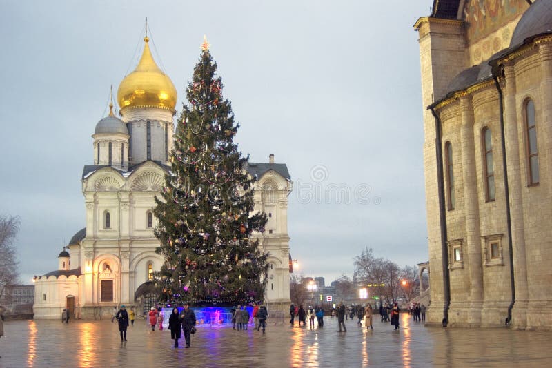 Moscow Kremlin. UNESCO World Heritage Site. Archangels cathedral and Christmas tree. Color photo. People walk on the Sobornaya Square. Moscow Kremlin. UNESCO World Heritage Site. Archangels cathedral and Christmas tree. Color photo. People walk on the Sobornaya Square.