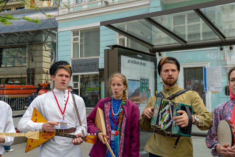 MOSCOW, RUSSIA - MAY 9, 2019: Immortal regiment procession in Victory Day. A man playing accordion balalayka, singing girl in traditional costumes. MOSCOW, RUSSIA - MAY 9, 2019: Immortal regiment procession in Victory Day. A man playing accordion balalayka, singing girl in traditional costumes