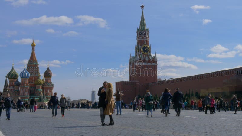 MOSCOU, RÚSSIA, o 9 de abril de 2017: Um casal é fotografado contra o contexto da torre do Kremlin e da manjericão do St