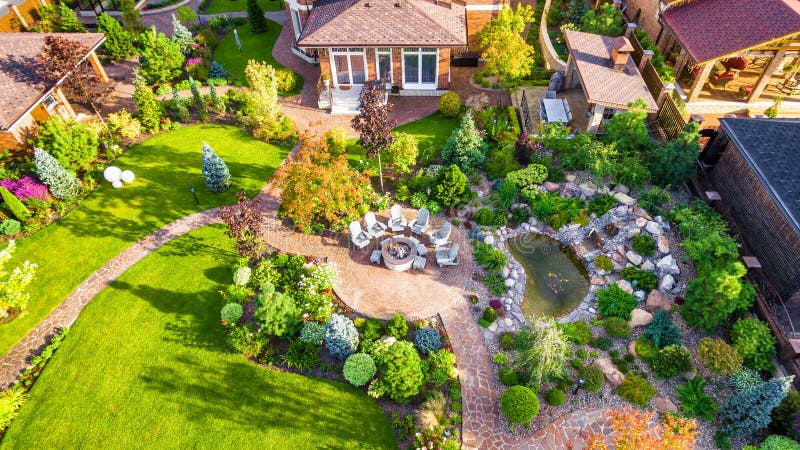 Landscape design with patio at residential house taken from above. Beautiful landscaping in home garden in summer