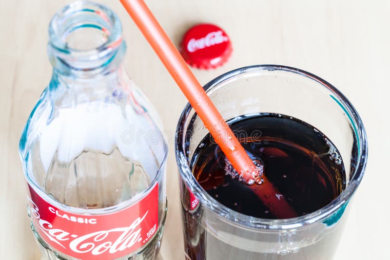 Bottle of Coca-Cola, drink in glass with straw