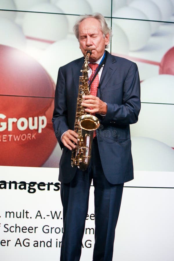 MOSCOW, RUSSIA - JUNE 19, 2012: Head of Scheer Management company August-Wilhelm Scheer play jazz theme the saxophone at Mission stock photo MOSCOW, RUSSIA - JUNE 19, 2012: Head of Scheer Management company August-Wilhelm Scheer play jazz theme the saxophone at Mission stock photo