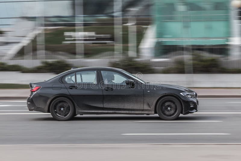 Moscow , Russia - March 2021: Black BMW M3 series car on the city road. Fast moving vehicle on the street. Sedan driving along the street in city with blurred background. Moscow , Russia - March 2021: Black BMW M3 series car on the city road. Fast moving vehicle on the street. Sedan driving along the street in city with blurred background