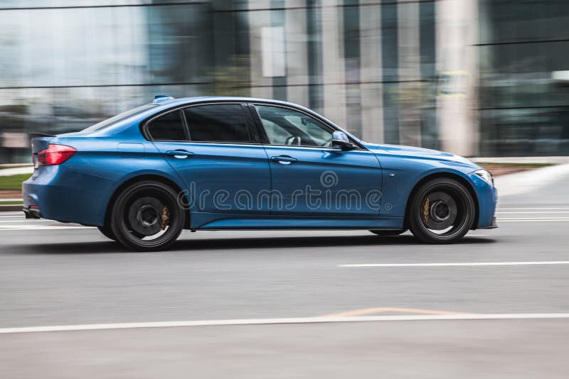 Moscow , Russia - May 2021: Blue BMW M3 series car on the city road. Fast moving vehicle on the street. Sedan driving along the street in city with blurred background. Moscow , Russia - May 2021: Blue BMW M3 series car on the city road. Fast moving vehicle on the street. Sedan driving along the street in city with blurred background