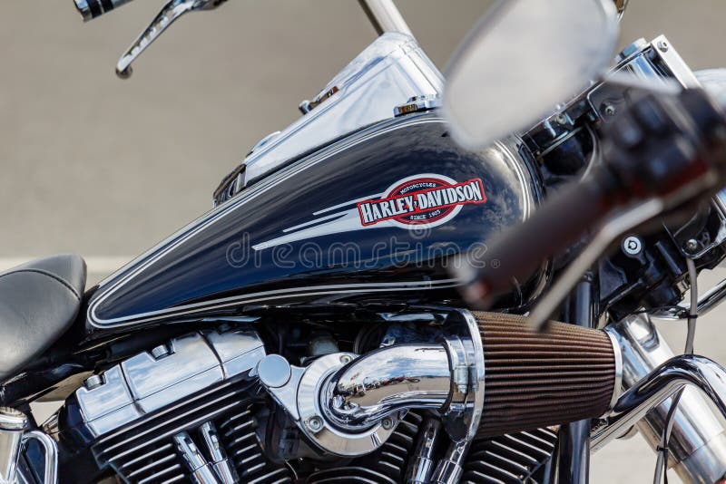 Moscow, Russia - May 04, 2019: Glossy black fuel tank of Harley Davidson motorcycle with emblem and chrome engine closeup. Moto