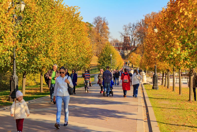 Moscow, Russia - October 17, 2018: Tourists walk along the alley at sunny autumn day in Tsaritsyno park in Moscow