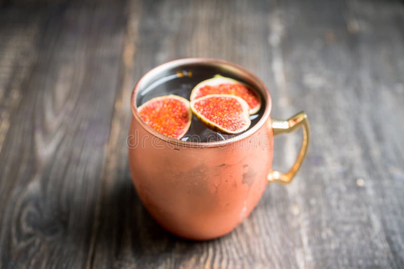 Moscow mule cocktail with figs and thyme on the rustic background. Selective focus. Shallow depth of field. Moscow mule cocktail with figs and thyme on the rustic background. Selective focus. Shallow depth of field.