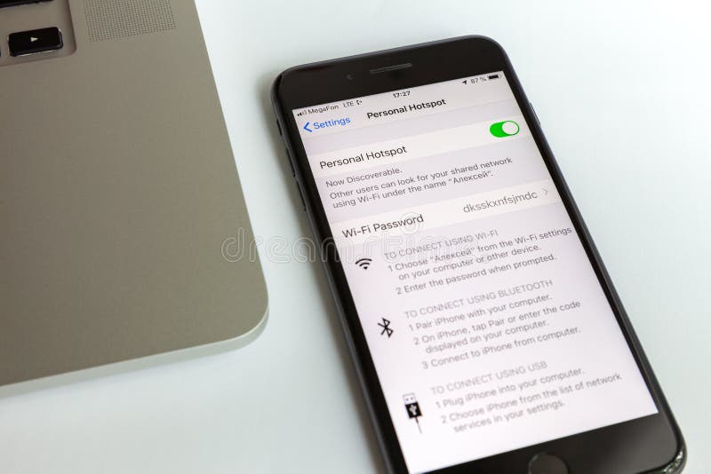 Moskva/Ryssland - Juli 10, 2019: Svart iPhone 8 plus och MacBook Modemet möjliggöras på skärmen royaltyfria bilder Moskva/Ryssland - Juli 10, 2019: Svart iPhone 8 plus och MacBook Modemet möjliggöras på skärmen royaltyfria bilder