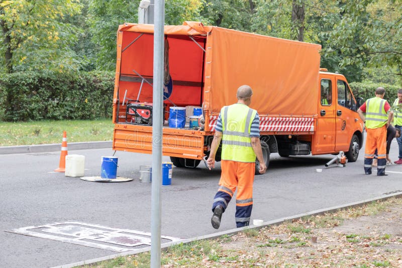 MOSKVA RYSSLAND - SEPTEMBER 09, 2018: Arbetare för vägunderhåll, roadmen som reparerar asfalt i staden i sommar royaltyfri foto MOSKVA RYSSLAND - SEPTEMBER 09, 2018: Arbetare för vägunderhåll, roadmen som reparerar asfalt i staden i sommar royaltyfri foto