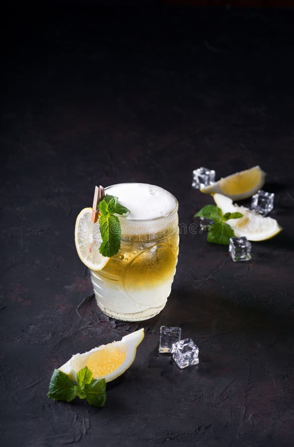 Moskvamulacoctail på en mörk bakgrund Kall drink, i lager vitt och gult med vodka, kryddig ingefärsdricka och limefrukt arkivfoton Moskvamulacoctail på en mörk bakgrund Kall drink, i lager vitt och gult med vodka, kryddig ingefärsdricka och limefrukt arkivfoton