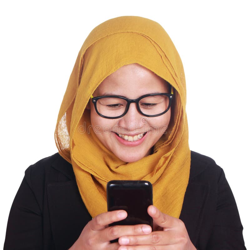 Moslemische lächelnde Frau beim Ablesen der Mitteilung am intelligenten Telefon stockfotos Moslemische lächelnde Frau beim Ablesen der Mitteilung am intelligenten Telefon stockfotos