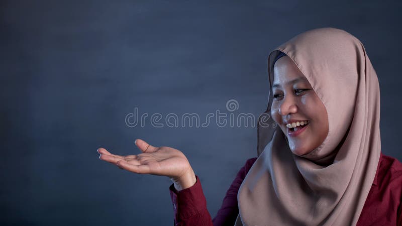 Moslimdame Presenting Something aan Haar Kant met Exemplaarruimte stock afbeelding Moslimdame Presenting Something aan Haar Kant met Exemplaarruimte stock afbeelding