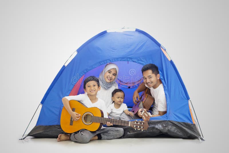 Moslimfamilie die van het kamperen met gitaren genieten stock foto's Moslimfamilie die van het kamperen met gitaren genieten stock foto's