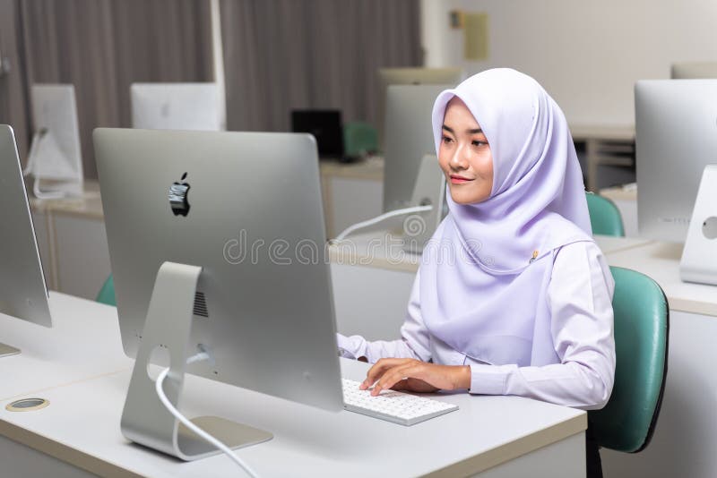 Moslimstudent die met de Computer van Apple werken iMac stock afbeeldingen Moslimstudent die met de Computer van Apple werken iMac stock afbeeldingen