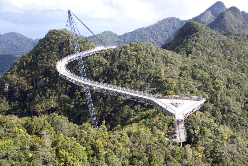 Curved suspension bridge for pedestrians on Gunung (Mount) Mat Cincang, Langkawi Island, Malaysia. This suspension bridge was the winner of a prestigious Swiss Design Award. It links the twin peaks of the mountain overlooking the world’s oldest tropical rainforest and crystal clear waters of Langkawi Island. Curved suspension bridge for pedestrians on Gunung (Mount) Mat Cincang, Langkawi Island, Malaysia. This suspension bridge was the winner of a prestigious Swiss Design Award. It links the twin peaks of the mountain overlooking the world’s oldest tropical rainforest and crystal clear waters of Langkawi Island.