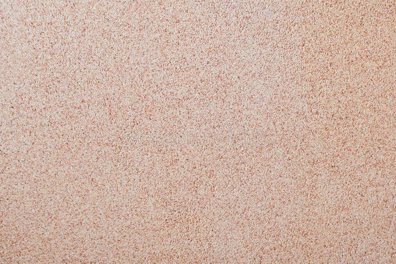Mot bakgrunden av spritt litet grus för sand en stensmula Textur av en yttersida av en vägg, ljus färg arkivbilder Mot bakgrunden av spritt litet grus för sand en stensmula Textur av en yttersida av en vägg, ljus färg arkivbilder