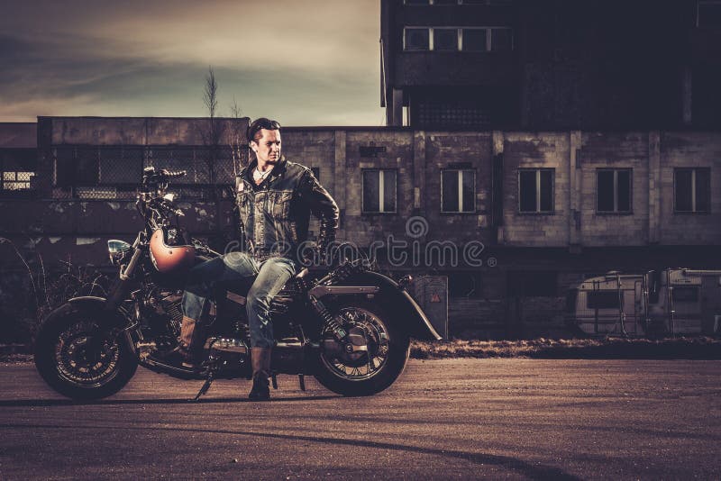 Motard et sa moto de style de bobber photo stock Motard et sa moto de style de bobber photo stock