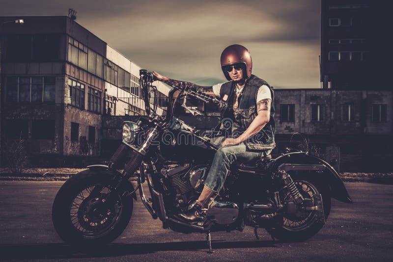 Motard et sa moto de style de bobber images libres de droits Motard et sa moto de style de bobber images libres de droits