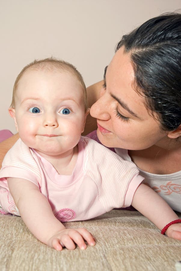 Mother and baby on bed, smiling