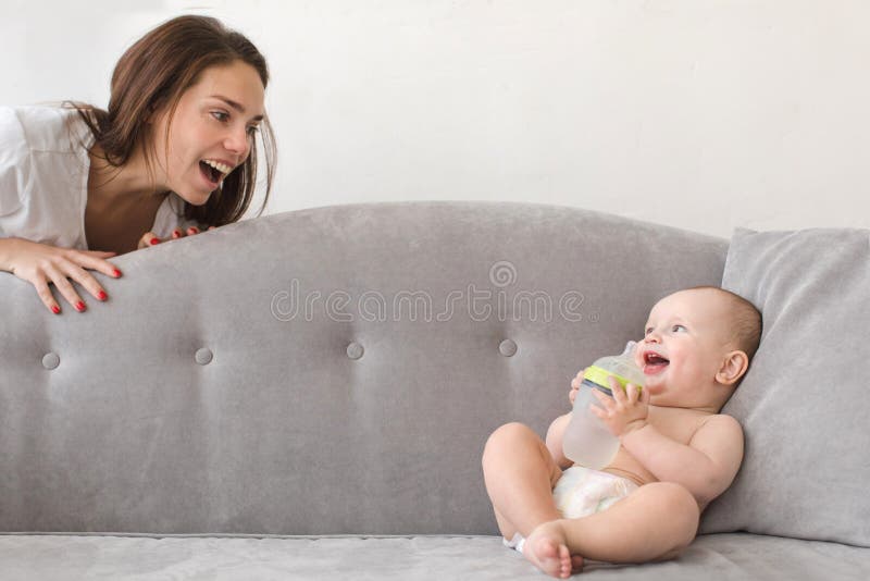 Mother and baby boy are playing on couch