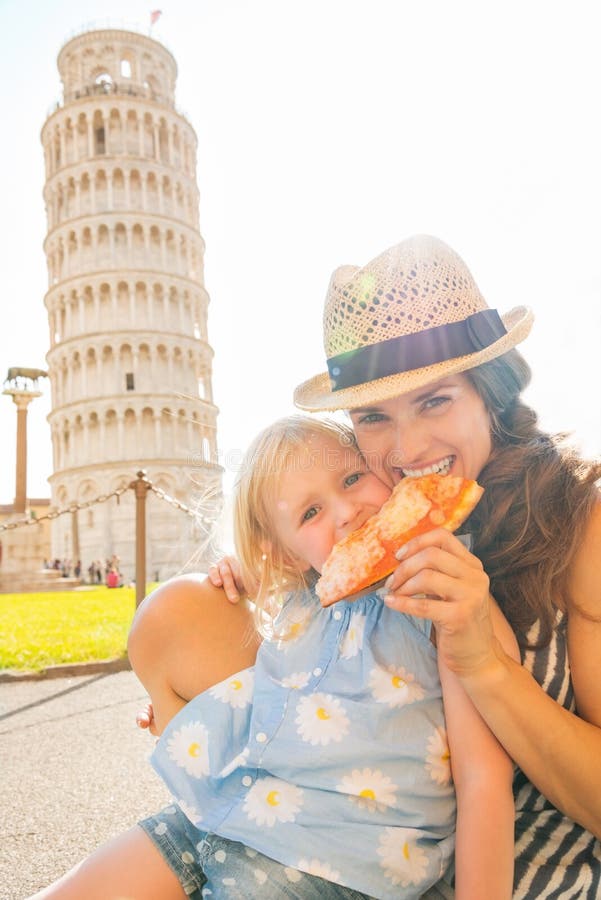 Feliz madre a un nino comer una hoja circular grande de masa ligera antes pendiente la Torre de,,.