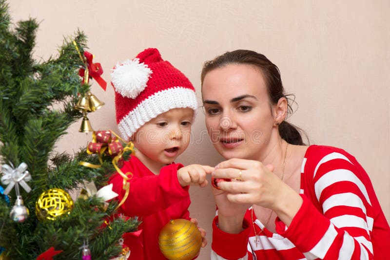 Mother with baby near the Christmas tree stock photo Mother with baby near the Christmas tree stock photo
