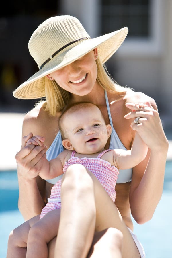 Mother and baby on vacation by swimming pool