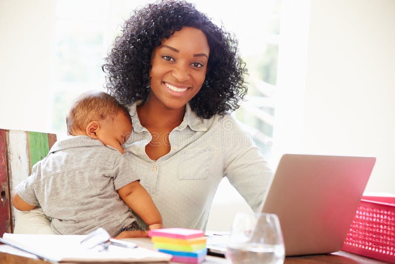 Mother With Baby Working In Office At Home