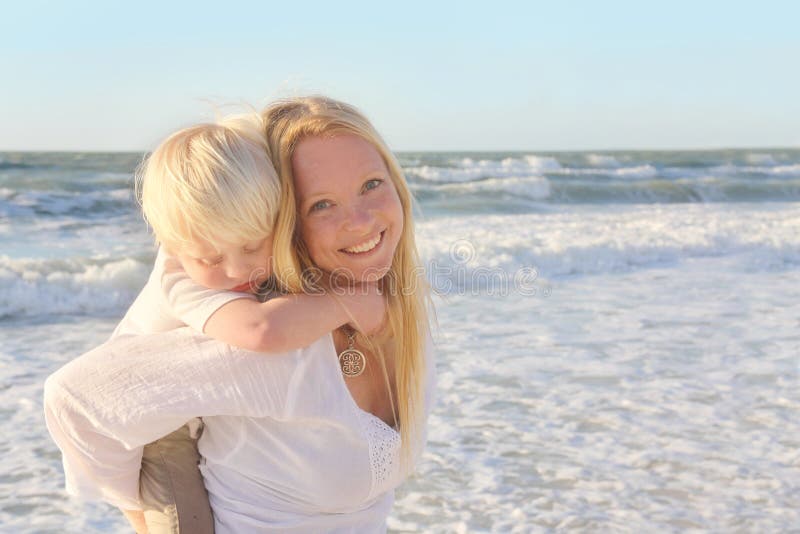 Mother Carrying Young Child Piggyback Through Ocean Water