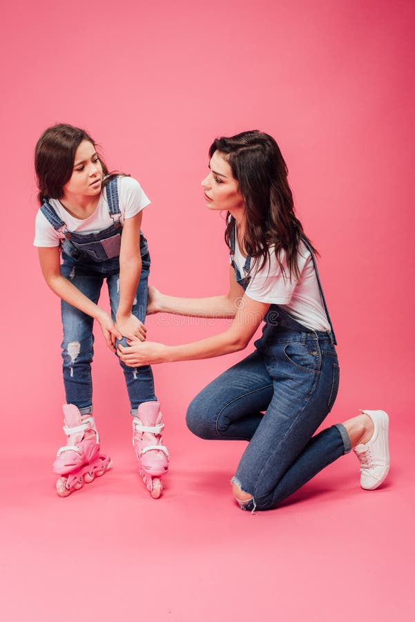 Mother Checking On Hurt Knee Of Daughter In Roller Blades ...