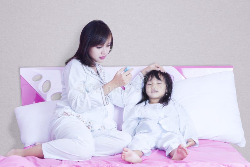 Mother checking temperature her child stock photos Mother checking temperature her child stock photos