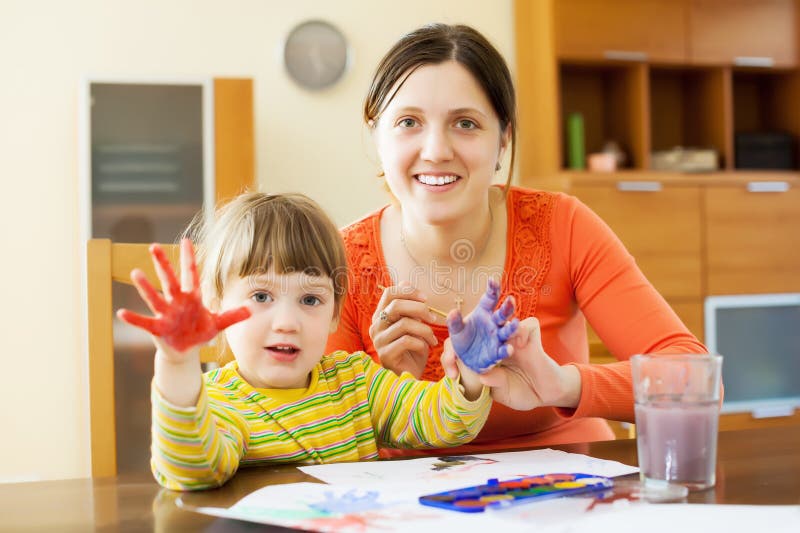 Happy mother and her child drawing on paper with hand printing. Happy mother and her child drawing on paper with hand printing