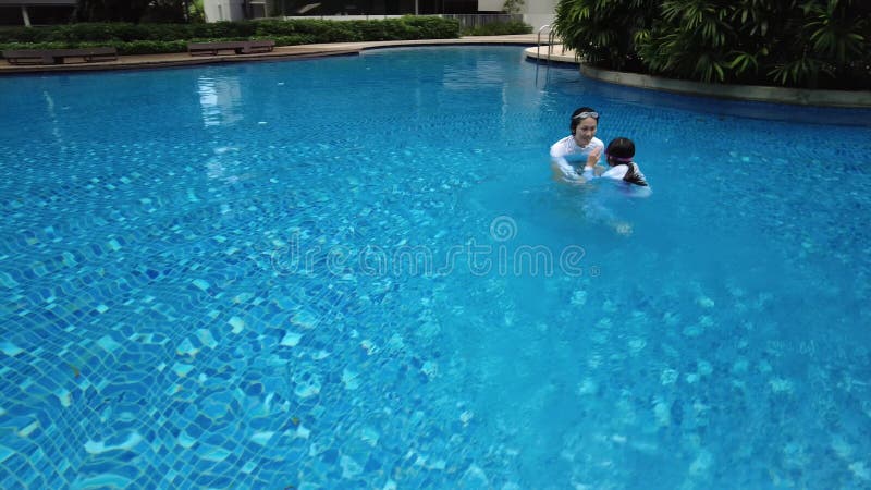 mother and child playing in a beautiful swimming pool in the condominium, Singapore