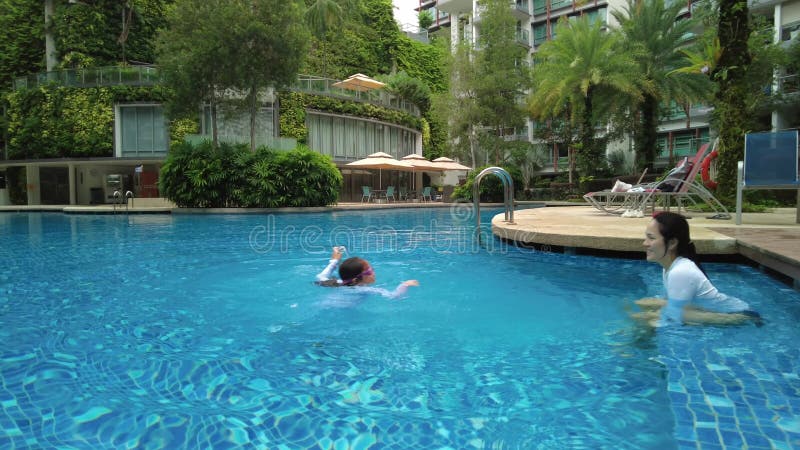 mother and child playing in a beautiful swimming pool in the condominium, Singapore