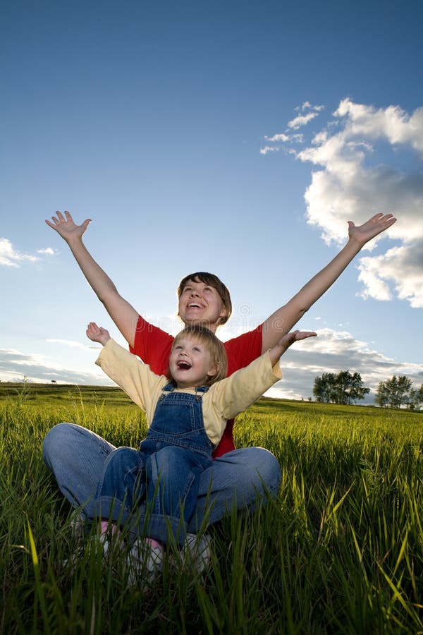 Mother and child sit in field