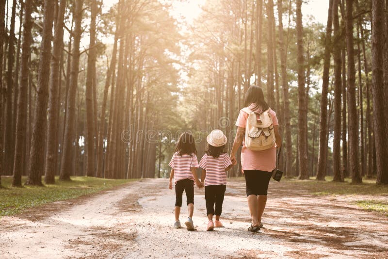 Mother and children daughter holding hand and walking together