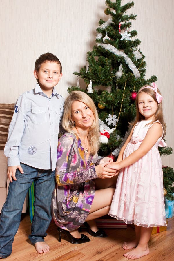 Mother and children near a fir-tree