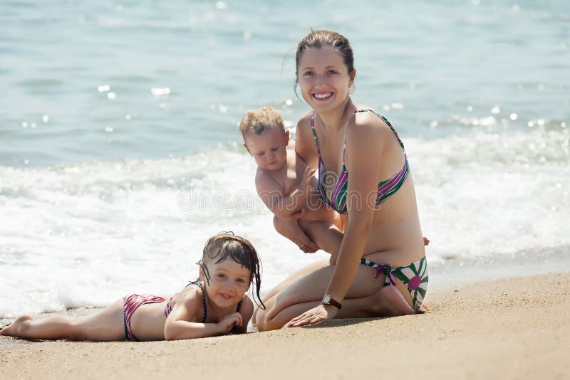 Mother with children on sand beach stock photos Mother with children on sand beach stock photos