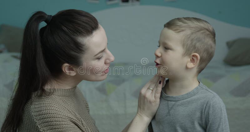 Mother Cleaning Face of a Child with a Cotton Pad