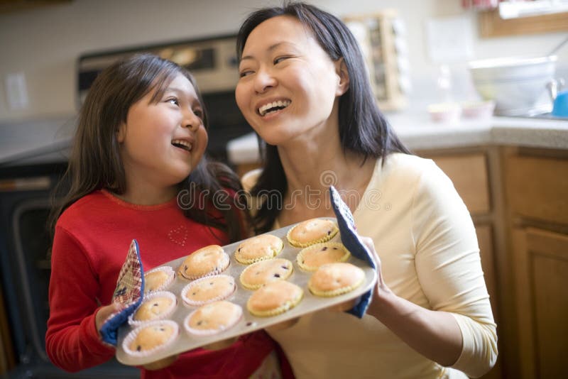 Mother and daughter baking muffins