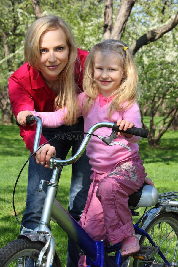 Mother with daughter on bicycle in spring