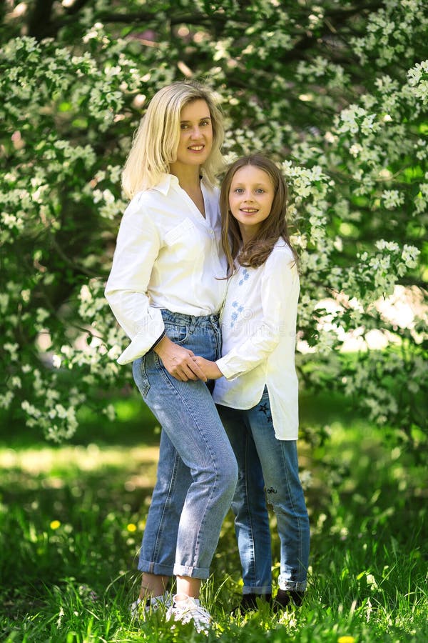 Mother and daughter in the blooming rose gardens of Apple trees. Happy motherhood. Beautiful family portrait stock photos Mother and daughter in the blooming rose gardens of Apple trees. Happy motherhood. Beautiful family portrait stock photos