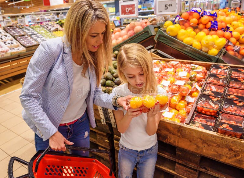 Mother and daughter buying ecologically grown fruits and vegetables