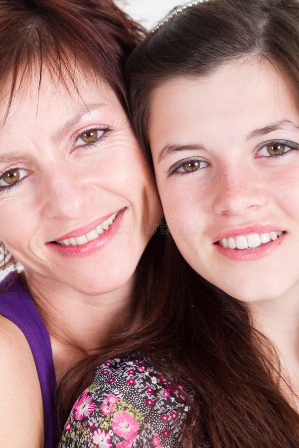 Happy Middle aged mom and teen daughter closeup portrait in studio. Happy Middle aged mom and teen daughter closeup portrait in studio