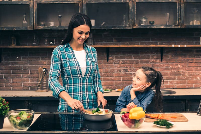Mother and daughter cooking on kitchen stock photos Mother and daughter cooking on kitchen stock photos