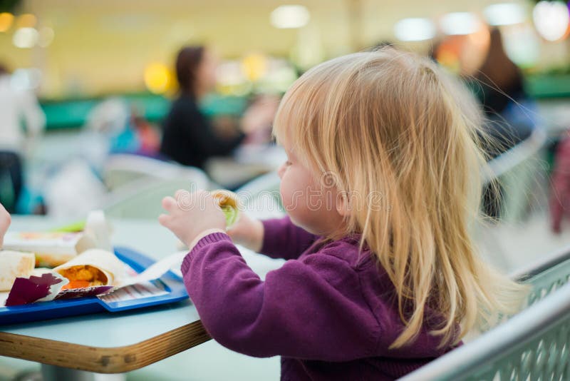 Mother and daughter dinning fast food meal in mall