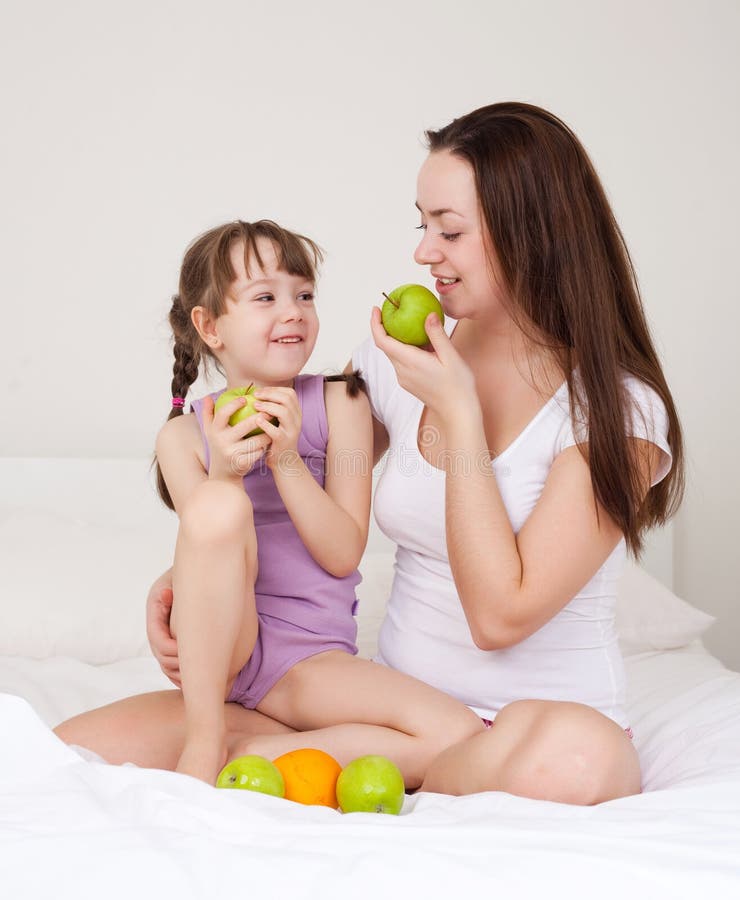 Mother and daughter eat apples