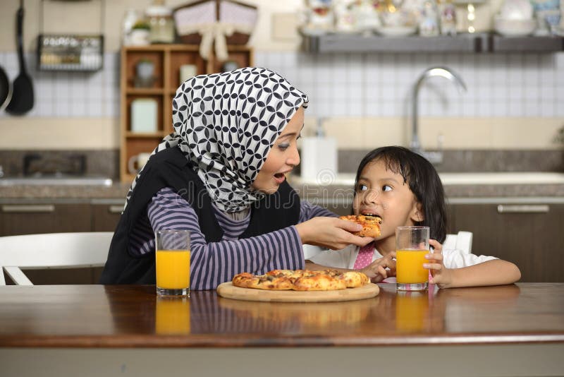 Mother And Daughter Eating Pizza