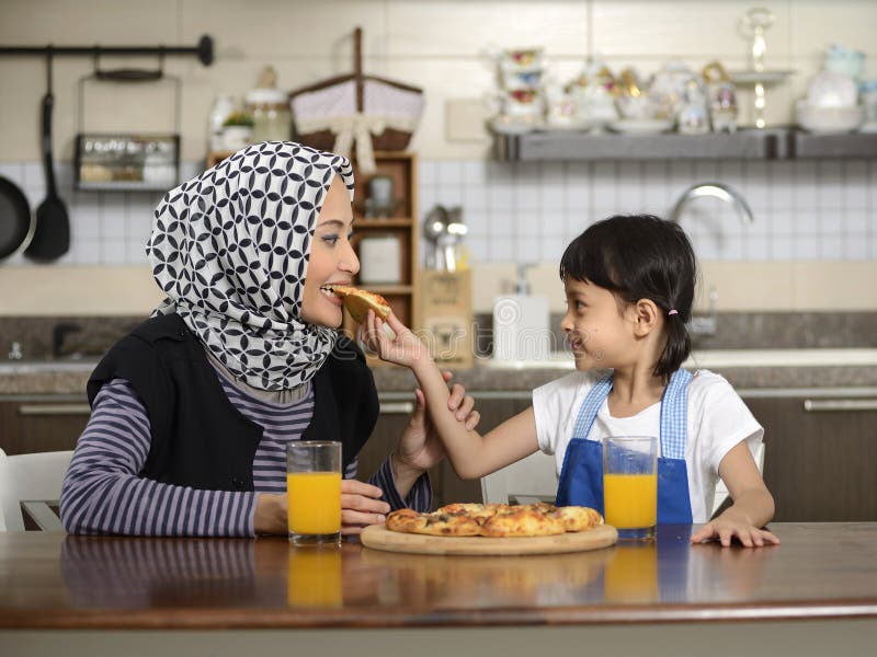 Mother And Daughter Eating Pizza